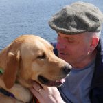 Man in a flat cap with golden labrador